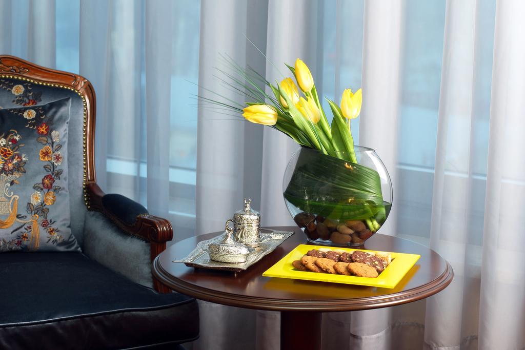 Orion Hotel Bischkek Exterior foto A table with a vase of flowers